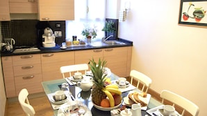 Une cuisine moderne avec des meubles en bois, une machine à café, un évier et une table à manger dressée pour le petit-déjeuner.