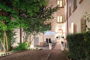 A hotel entrance with a sign, a pathway, and trees. - ArtHotel City (Nuremberg)