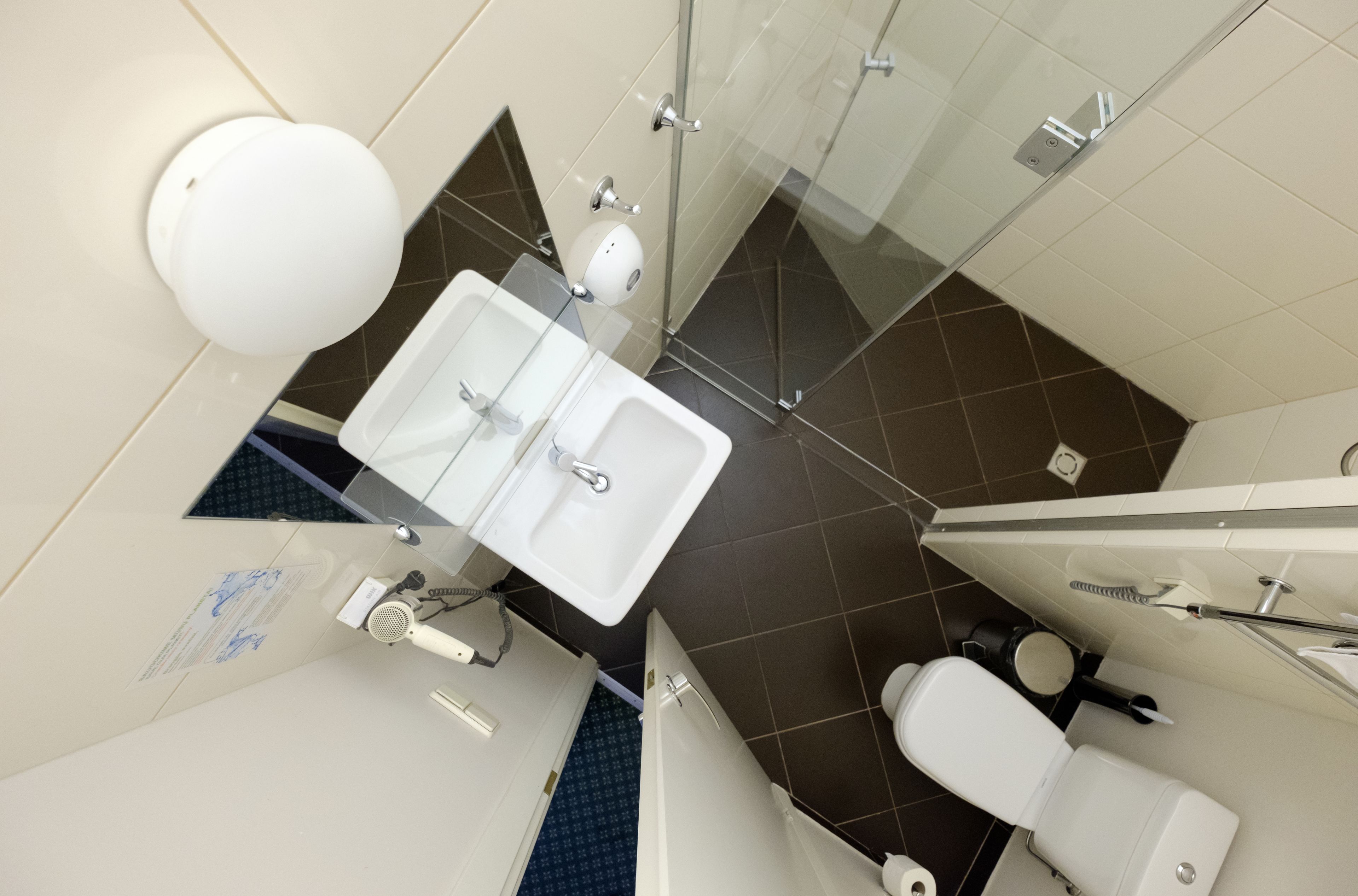 Un baño moderno con lavamanos doble, inodoro y cabina de ducha de vidrio.