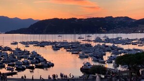 A marina with numerous boats docked, surrounded by hills and a sunset sky. - Hotel Relais al Convento (Vezzano Ligure)