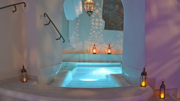 A spa area with a hot tub, tiled walls, and hanging lanterns. - Hotel Relais al Convento (Vezzano Ligure)