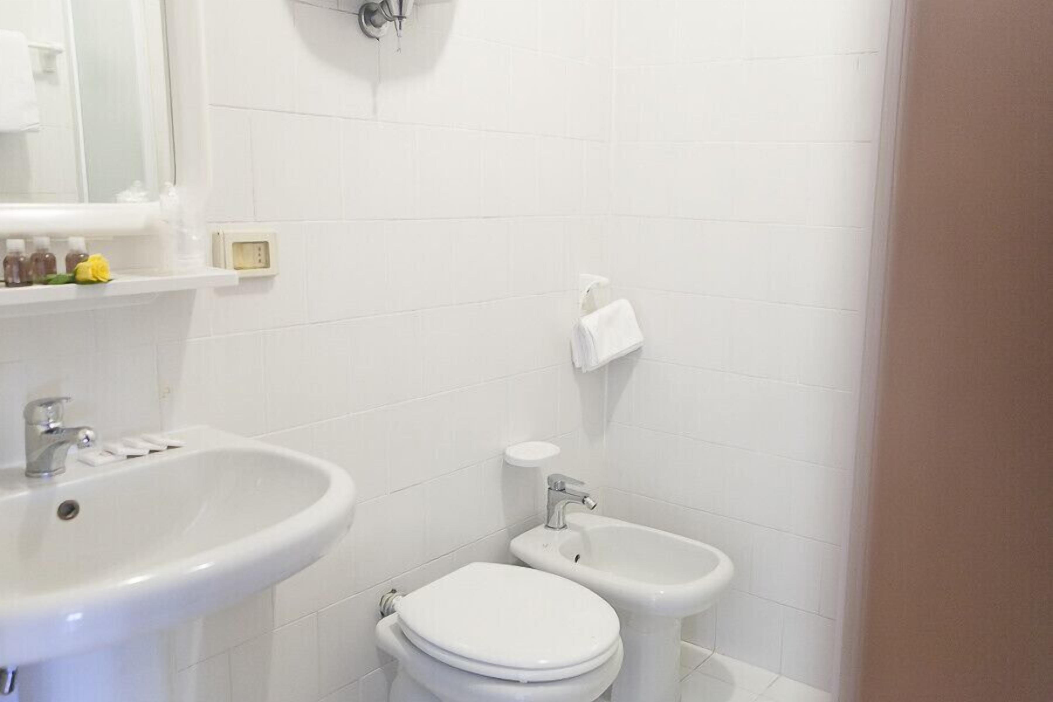 Une salle de bain équipée d’un lavabo, de toilettes et d’un bidet.