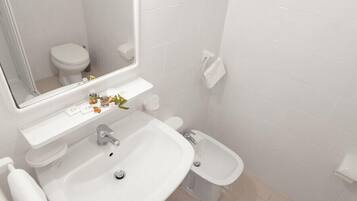 Un bagno moderno con lavandino bianco, specchio, water e bidet.