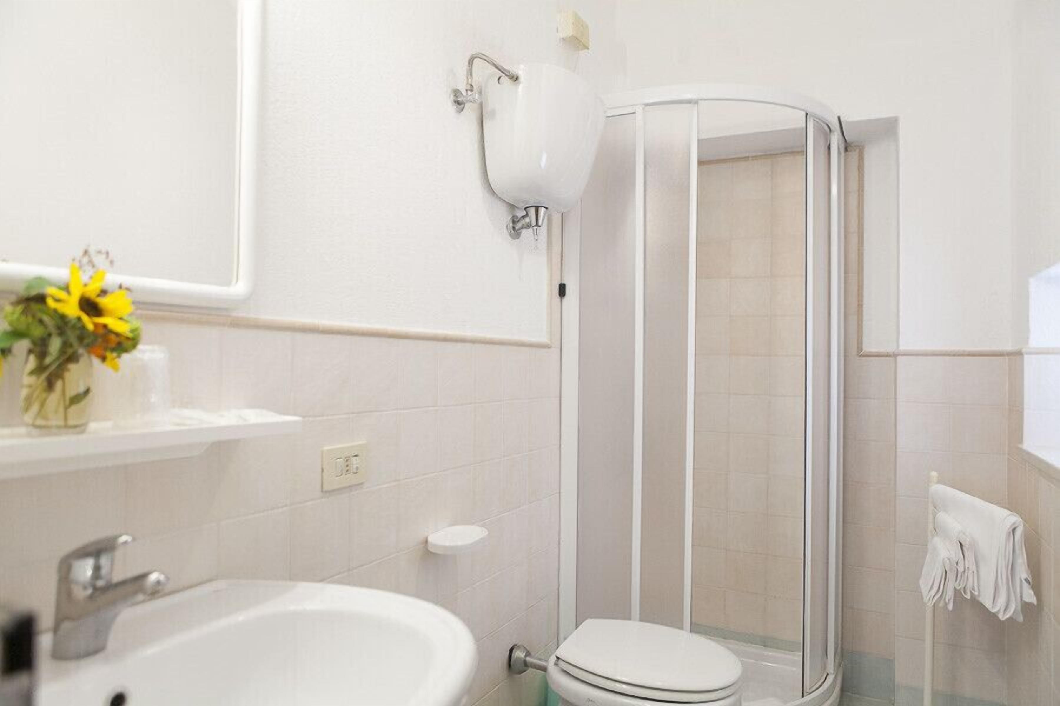 A bathroom with a bathtub, toilet, and a glass-enclosed shower.