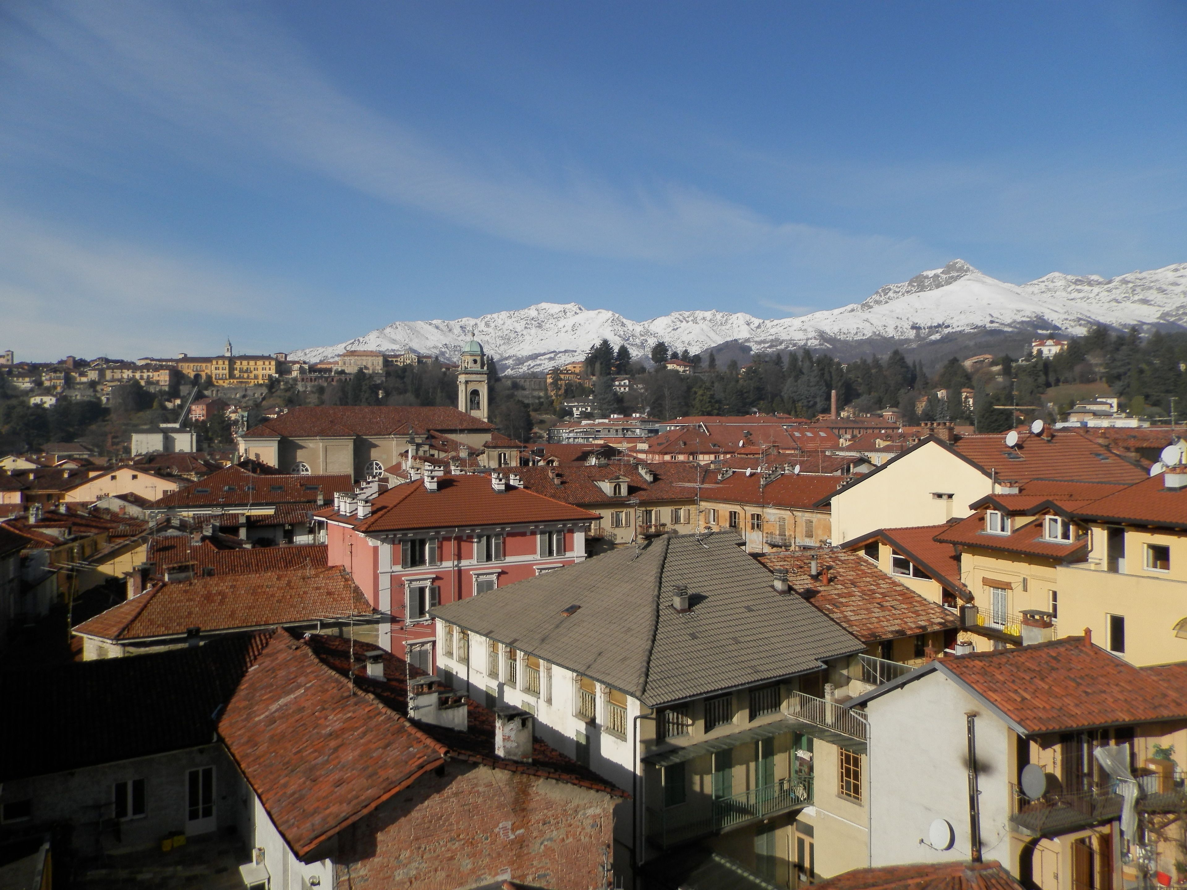 Una cittadina caratterizzata da architettura tradizionale, una chiesa imponente e montagne innevate sullo sfondo.