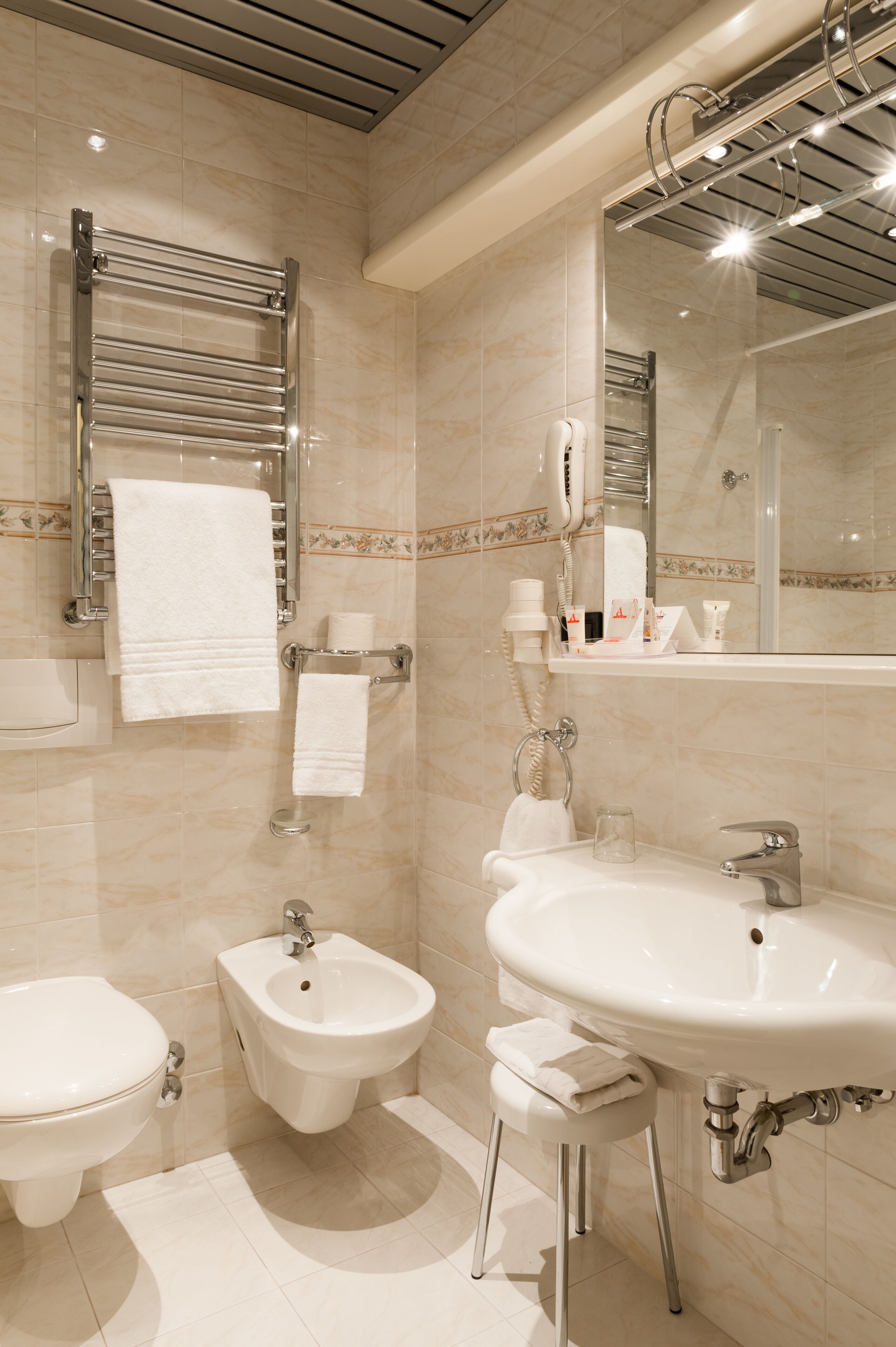 Un baño moderno con bidé, lavamanos e inodoro.