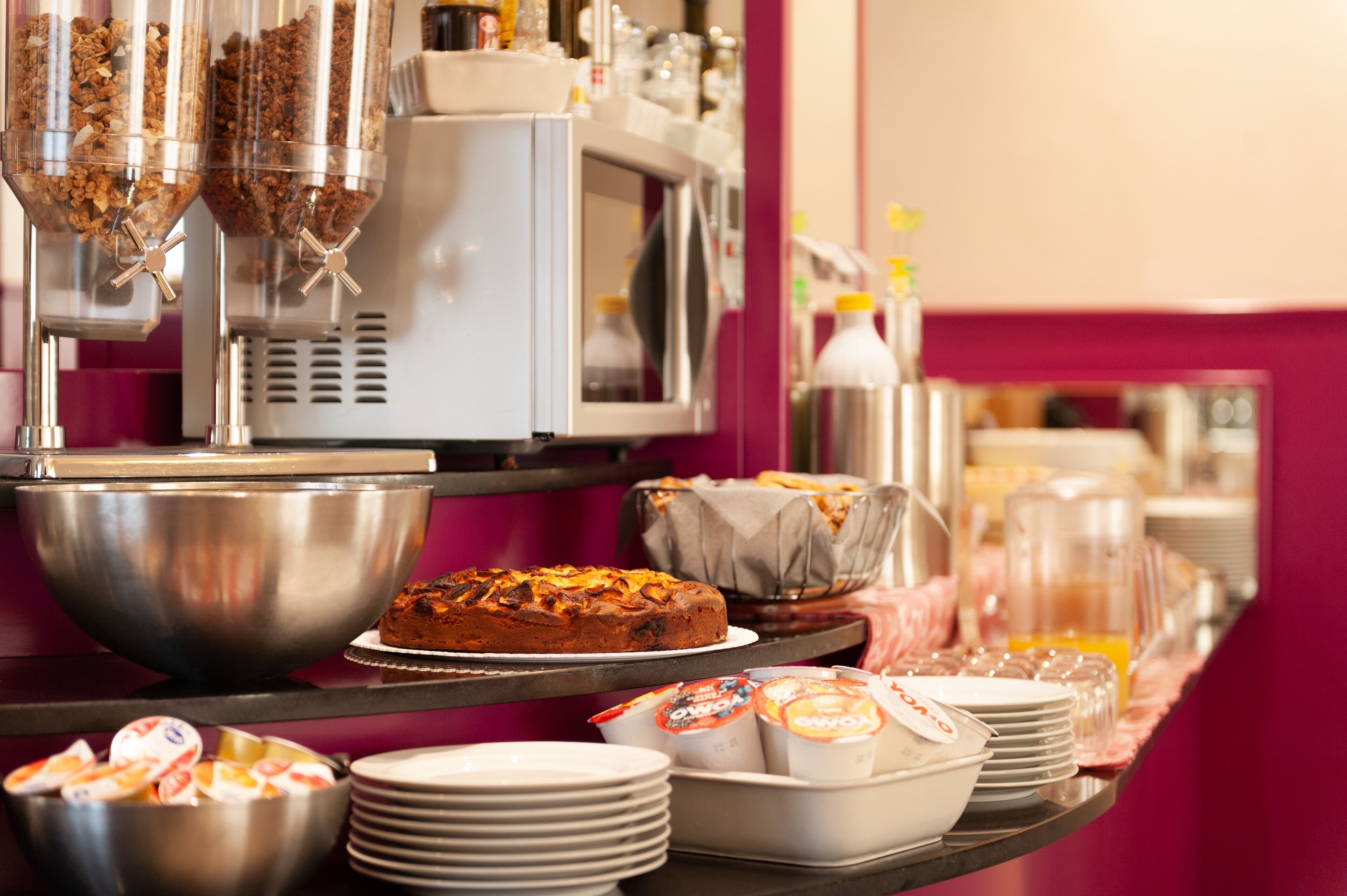 Una mesa de buffet con distintos alimentos y una máquina de café.