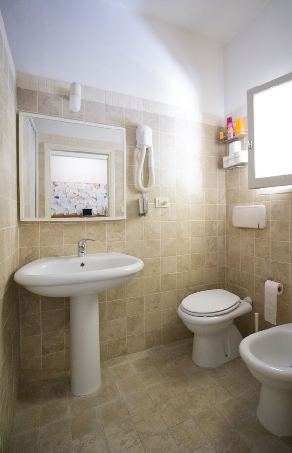 A bathroom with a sink, toilet, bidet, and a mirror. - Il Ghiro (Florence)