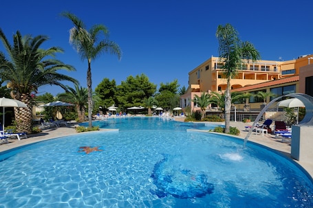 Una piscina al aire libre, sombrillas, sillones reclinables de piscina. Hotel I Melograni