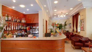 Una zona de bar con mostrador de madera, estantes con botellas y un área de estar con sillas y una mesa.