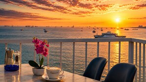 A sunset view from a balcony with a table, chairs, a coffee cup, and a potted plant. - Ayasofya Hotel - Special Class (Istanbul)