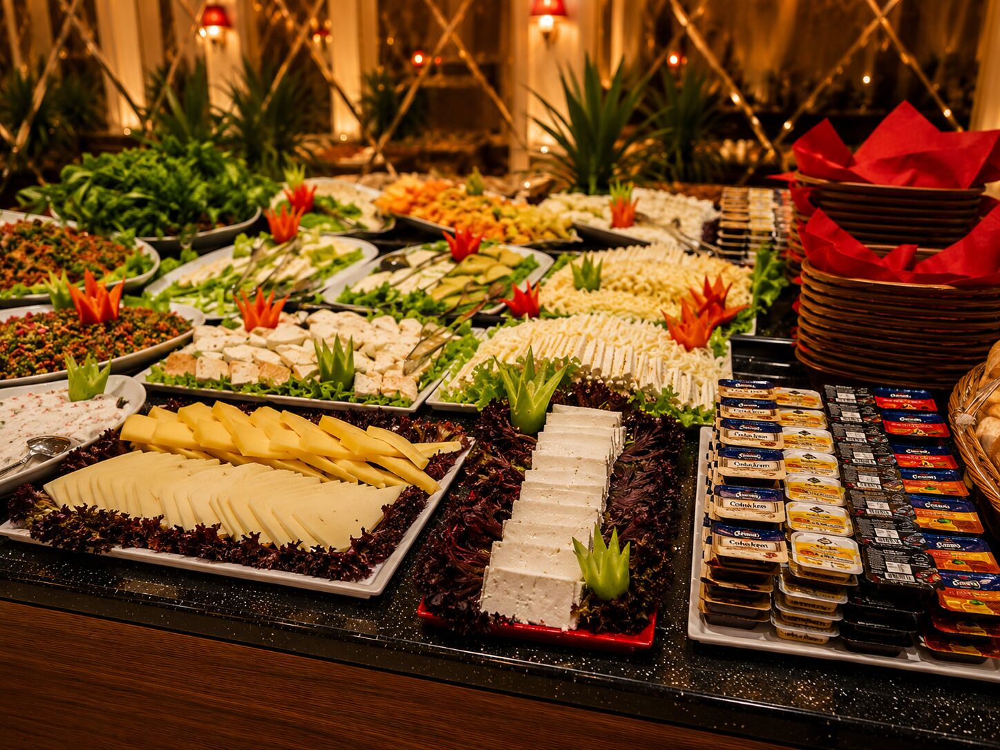 A buffet with various food items, including salads, cheeses, and desserts.