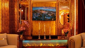 Un lobby lujoso con una gran pantalla de televisión, una chimenea y una decoración elegante.