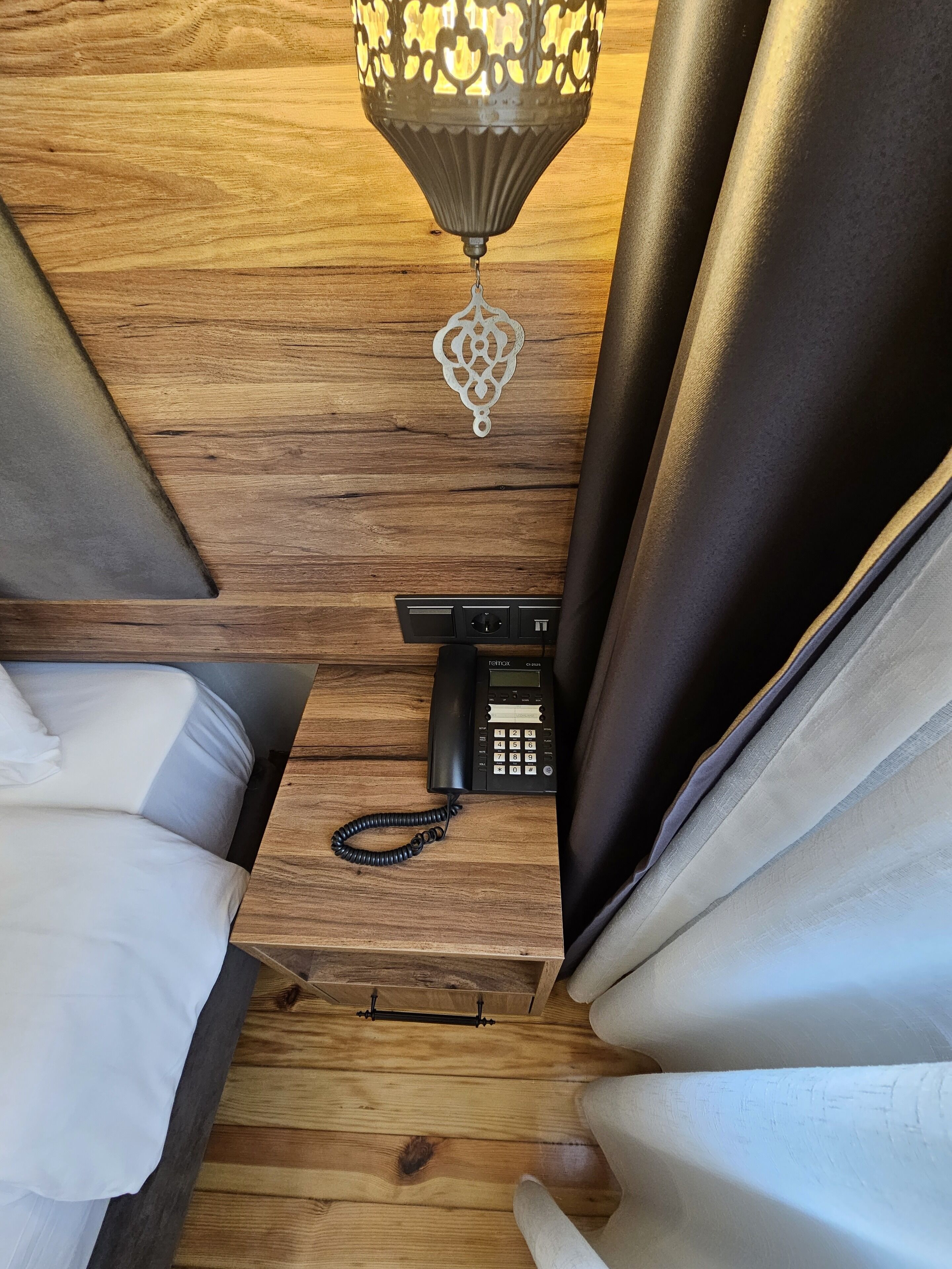 A wooden floor with a bed and a telephone on it.