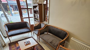 Un hall d’entrée accueillant, avec un canapé, des fauteuils, une table basse et un tapis à motifs.