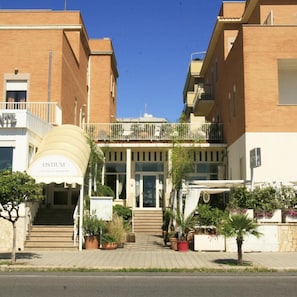 A hotel with a central entrance, potted plants, and a clear sky. - Hotel Sirenetta (Rome)