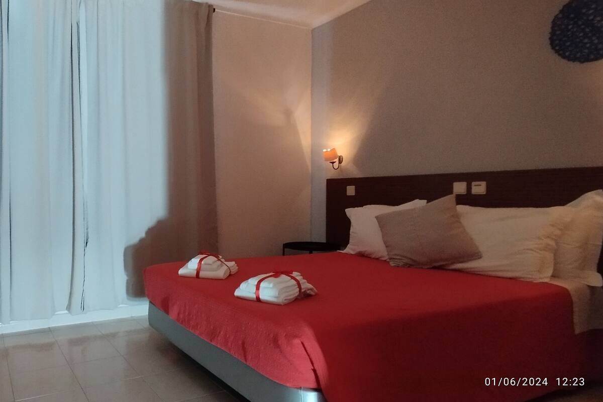 Une chambre d’hôtel avec un lit, un bureau et une télévision.