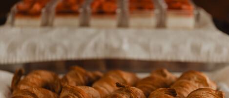 Un plateau de croissants et un autre plateau de desserts avec divers pâtisseries.