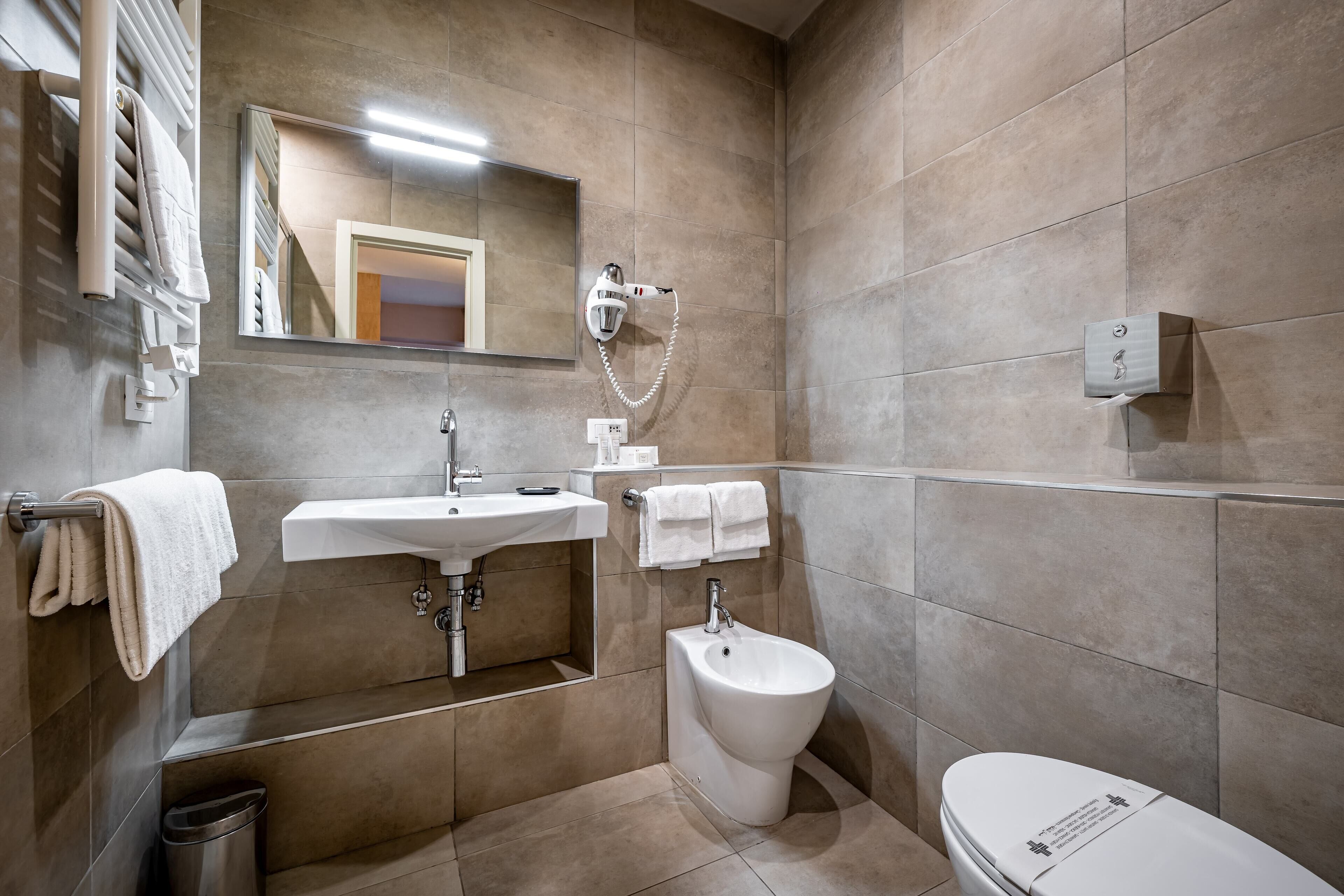 Un baño moderno con lavamanos, bidé e inodoro.