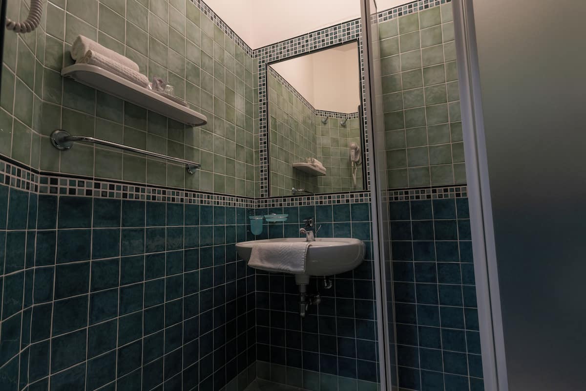 A bathroom with a sink, mirror, and towel rack.