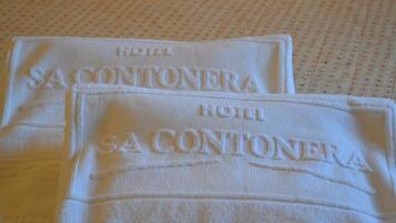 Two white towels with "HOTEL SA CONTONERA" embroidered on them.