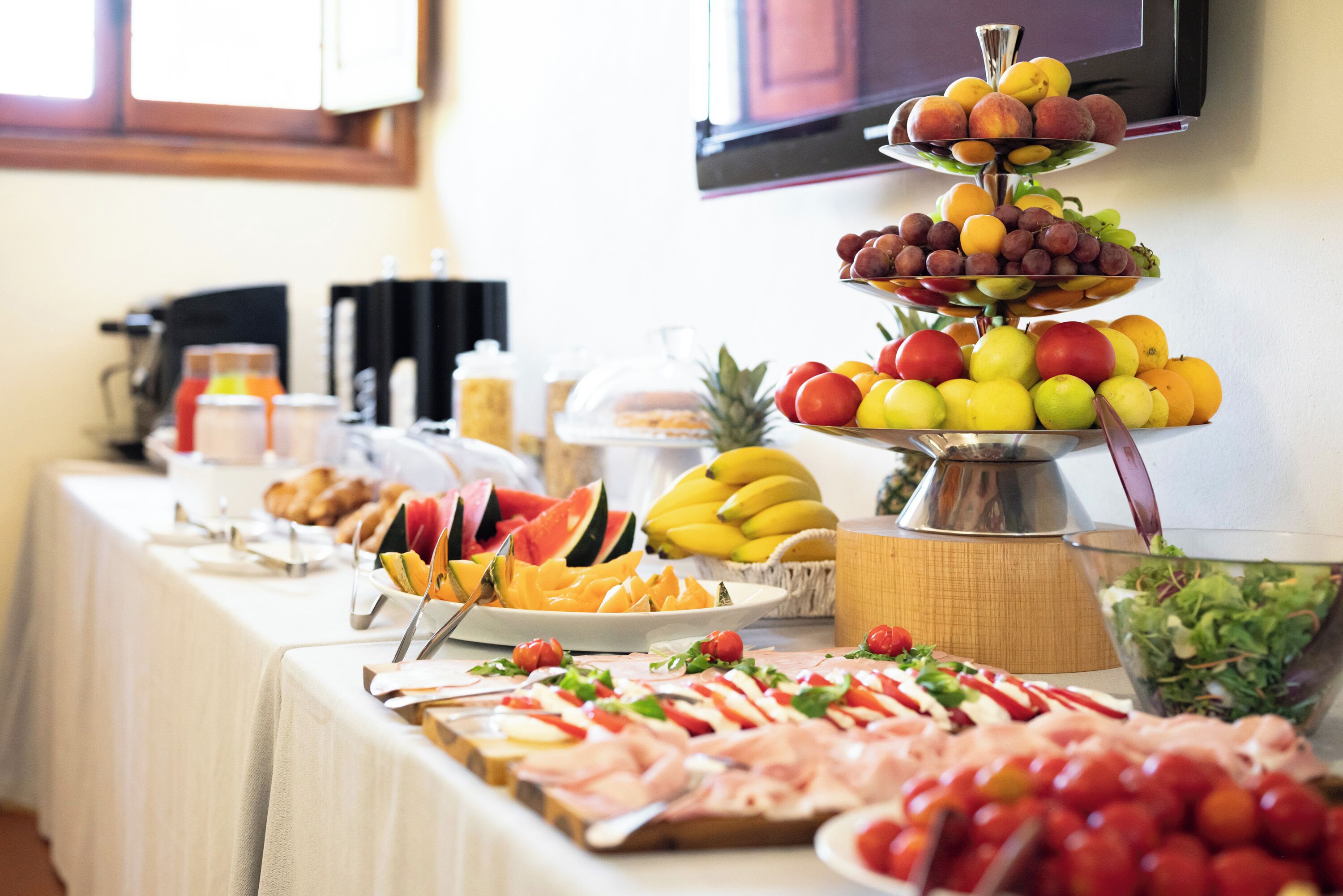 Ein Buffet mit verschiedenen Speisen, darunter Obst, Gemüse und Fleisch.
