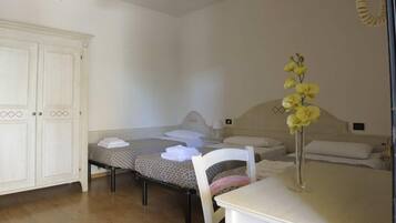 Ein kleines, sauberes Zimmer mit Bett, Stuhl, Tisch und Kleiderschrank.