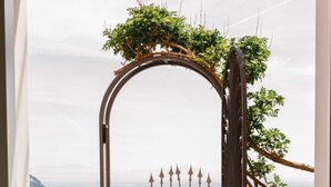 Une entrée sécurisée par un portail, offrant une vue sur la mer et les montagnes.