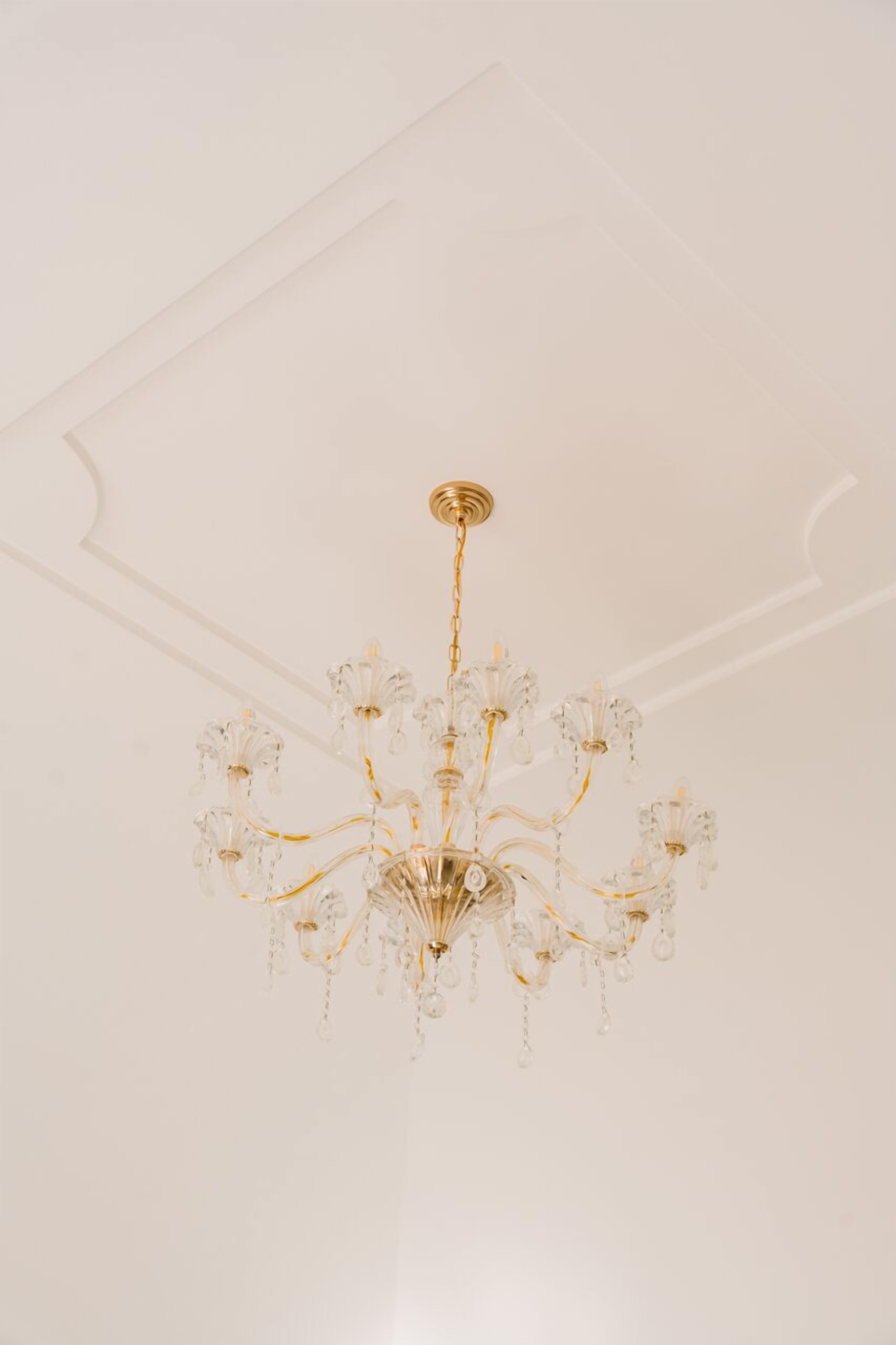 Un candelabro con múltiples brazos y adornos de cristal colgando del techo.