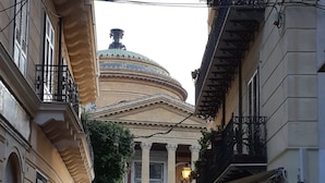 A cobblestone street with outdoor seating at a café, a historic building with a dome in the background, and a sign for 'SEMPOR'. - Cavour il Conte Camillo Bed&Breakfast (Palermo)