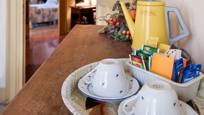 Une table à manger avec des théières, des tasses et un plateau rempli de différents plats.