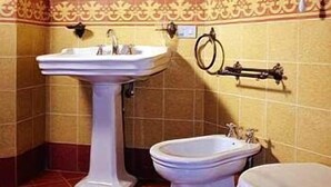 Une salle de bain équipée d’un lavabo sur colonne, d’un bidet et de toilettes.