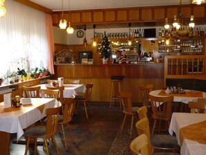 A restaurant with wooden furniture, a bar area, and a Christmas tree. - Hotel Gasthaus Steiger (Graefenthal)