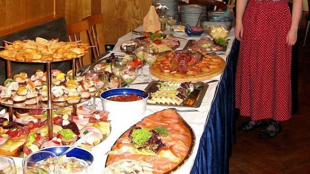A buffet table with various food items and a person standing beside it. - Hotel Gasthaus Steiger (Graefenthal)