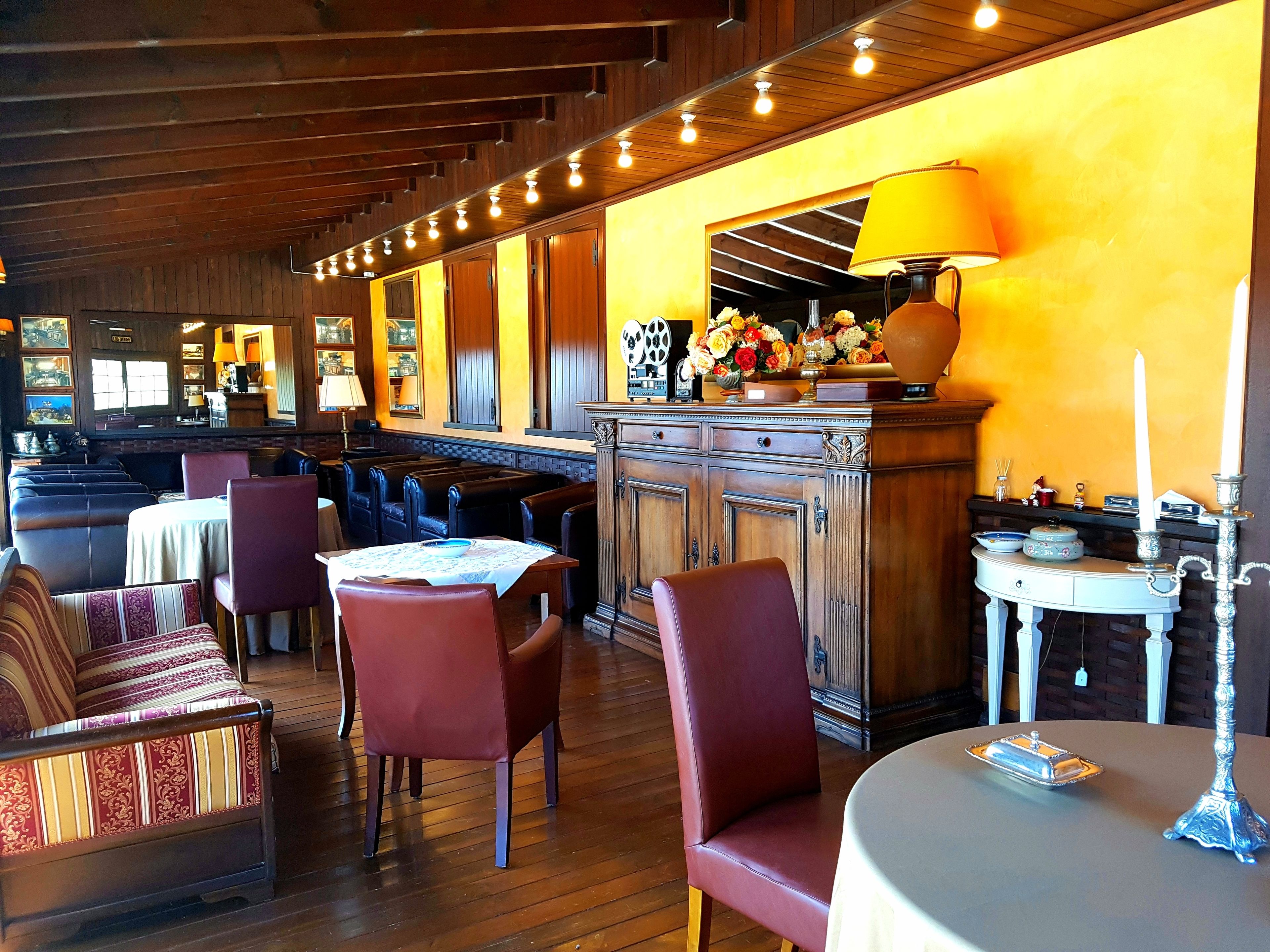 Een restaurant met houten zithoeken, tafels en een bar.