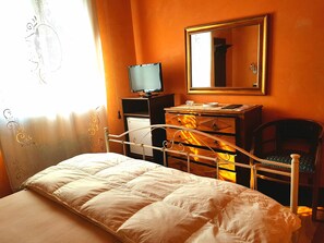 A bedroom with a bed, dresser, television, and a chair. - Villa Elisabetta (Galatina)