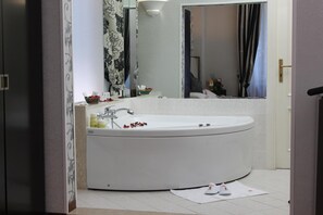 A modern bathroom with a freestanding bathtub, a mirror, and a sink. - Villa Ariccia (Ariccia)