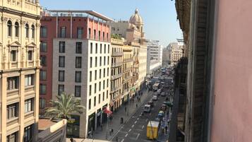 Vista de la calle con edificios, vehículos y peatones.