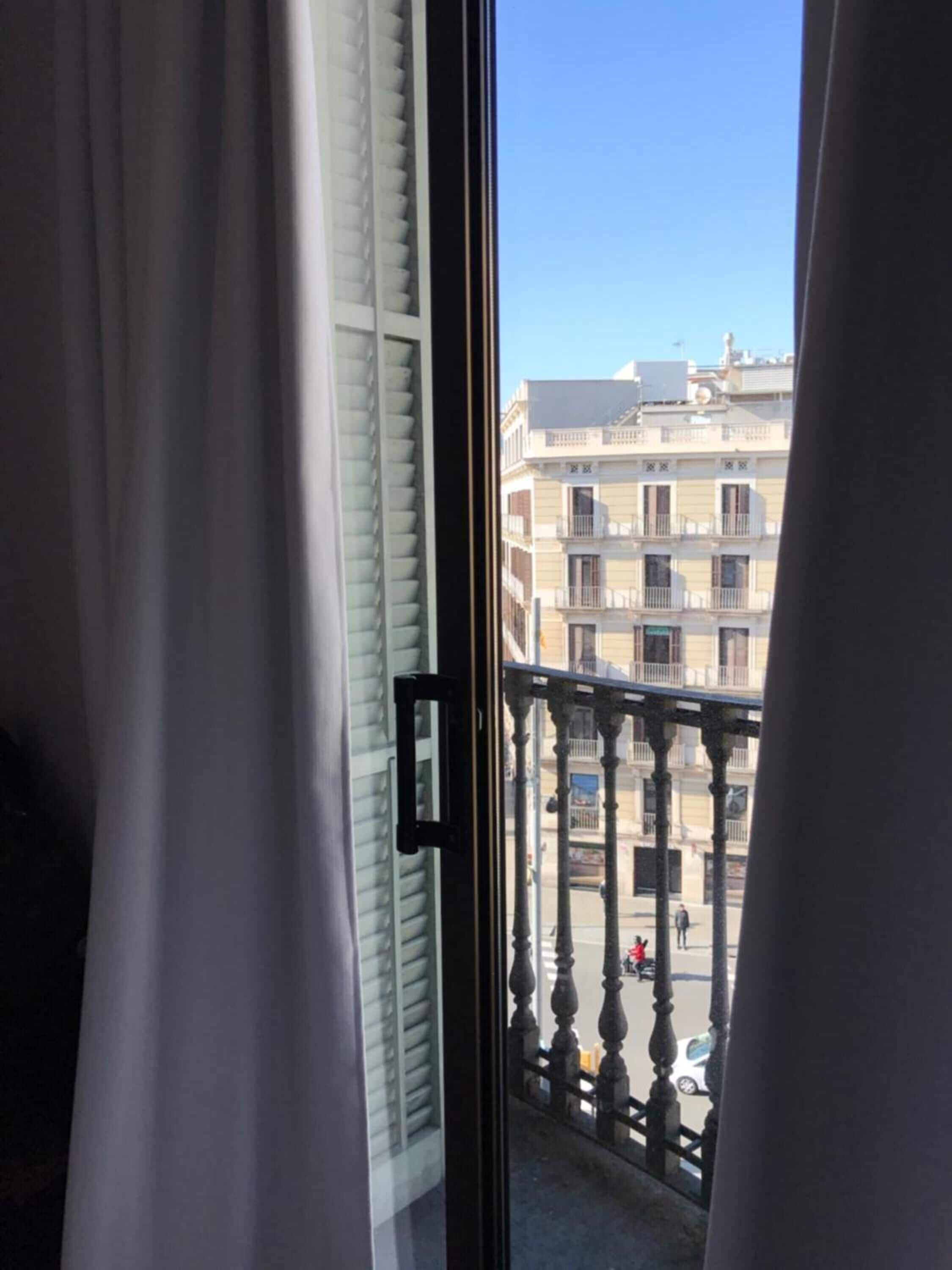 Un balcón con vistas a un edificio de varios pisos y balcones.