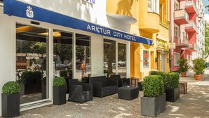 Arktur City Hotel set med udendørs siddepladser og krukker med planter.