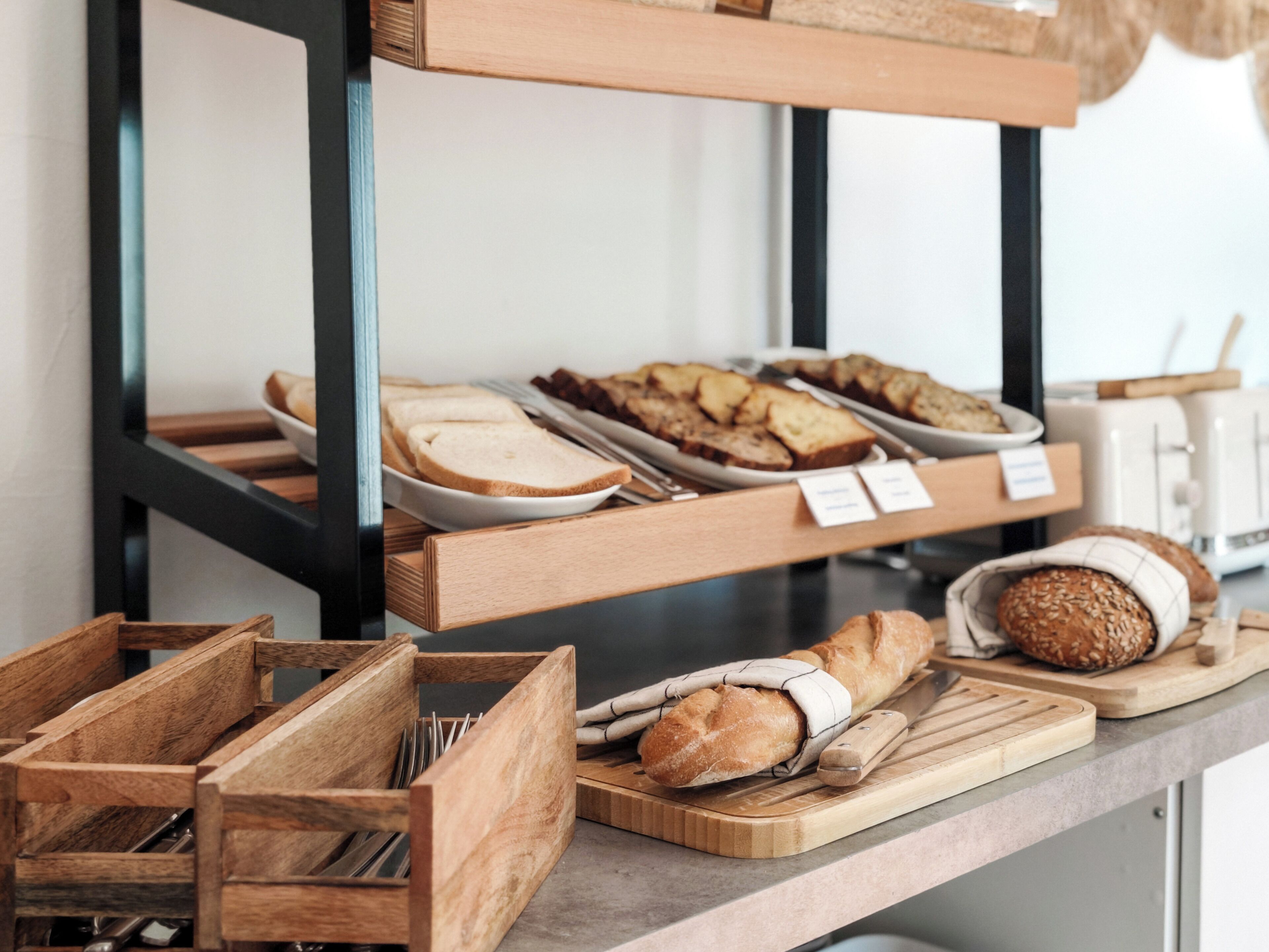 A bakery display with various breads and pastries.