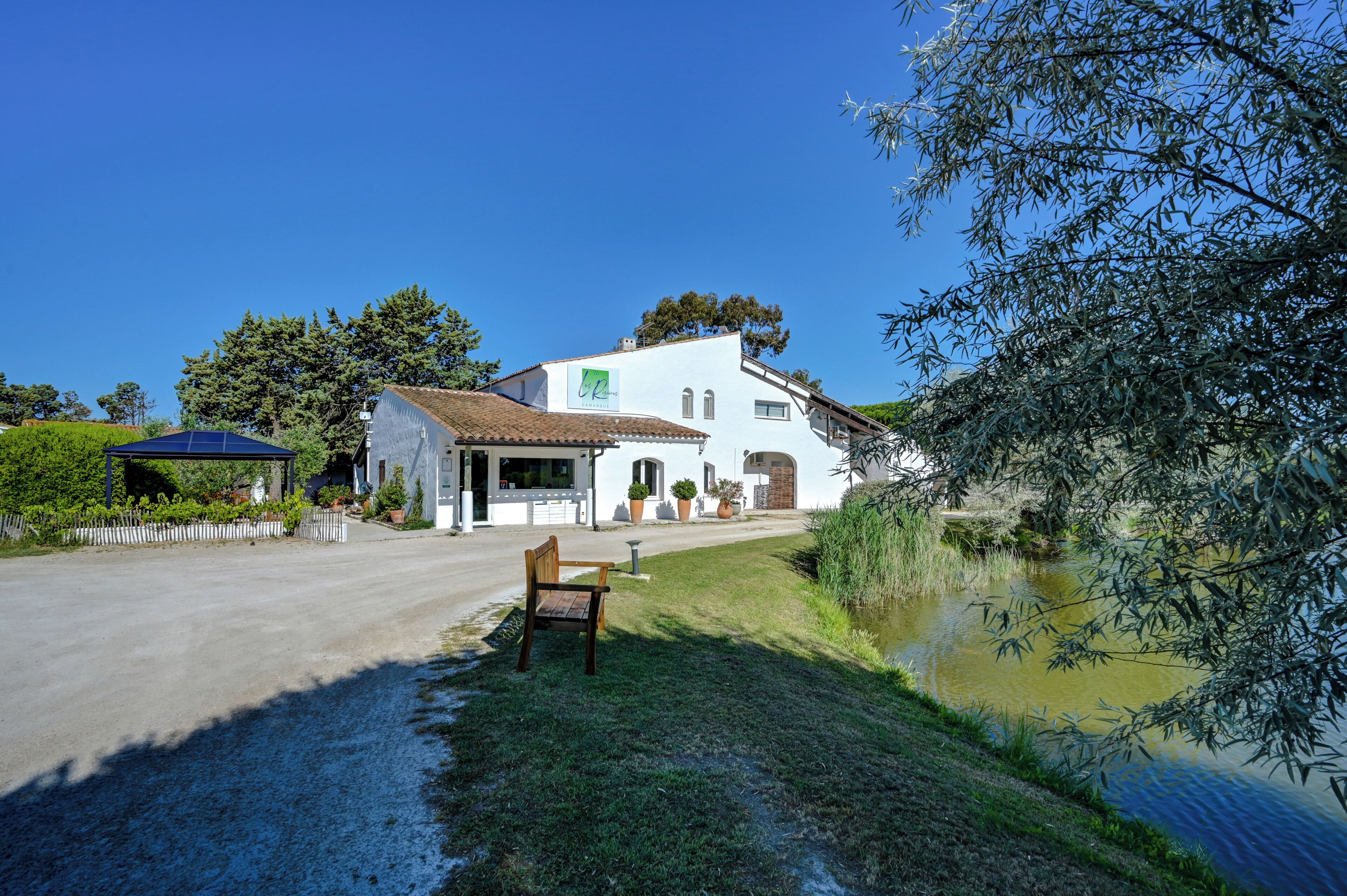Ein weißes Gebäude mit Garten und Teich.