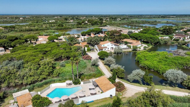 A residential area with a swimming pool, houses, and a river. - Hôtel les Rizières (Saintes-Maries-de-la-Mer)