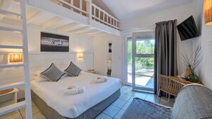 A bedroom with a bed, a ladder, a TV, and a window with curtains. - Hôtel les Rizières (Saintes-Maries-de-la-Mer)