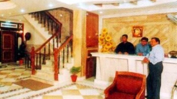 A lobby with a checkered floor, a staircase, and a reception desk. - Metro City (New Delhi)