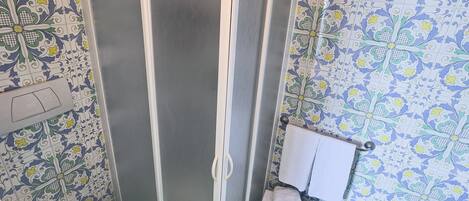 A bathroom with a shower enclosure, toilet, and bathtub.