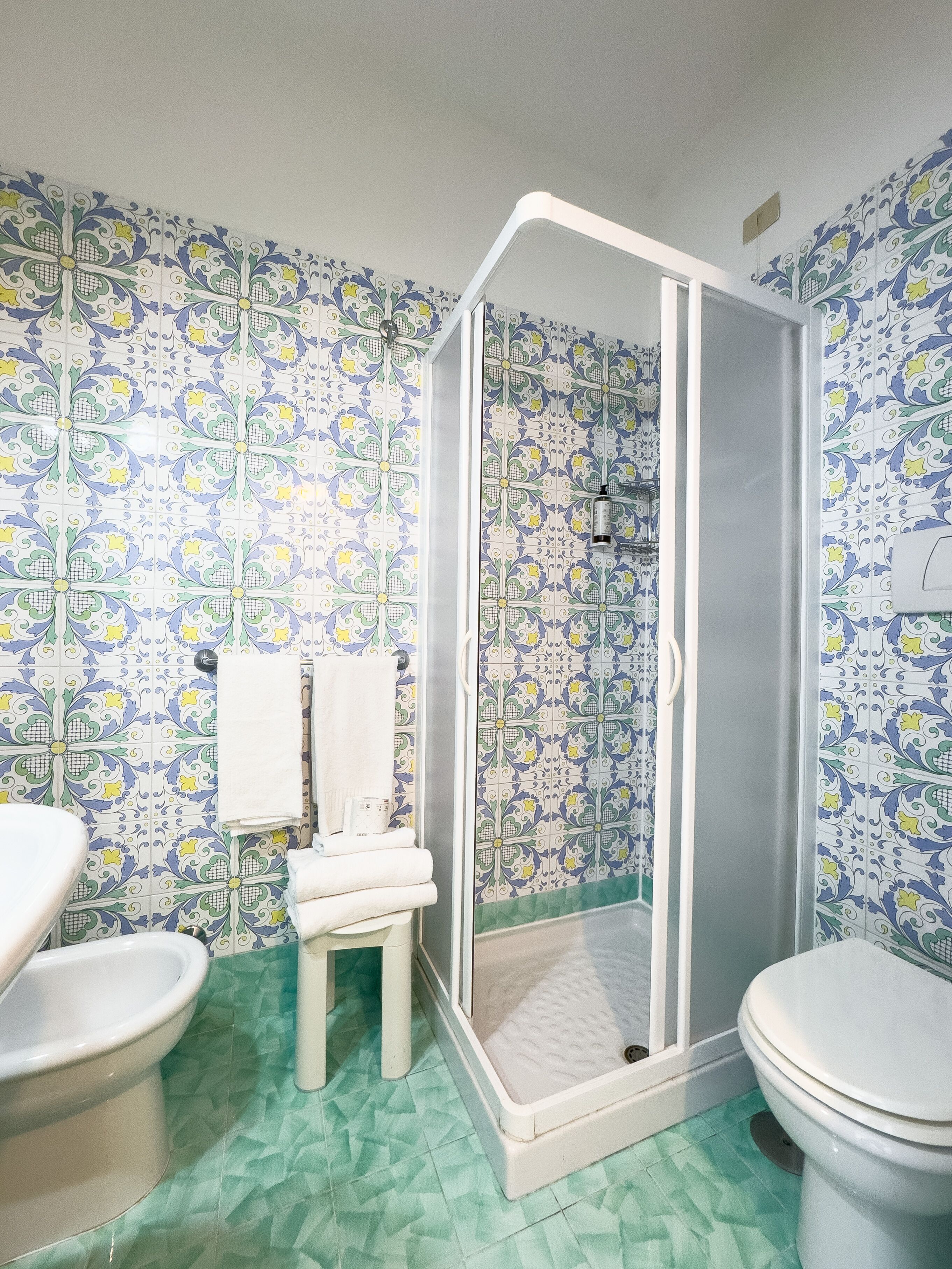 A bathroom with a shower, toilet, and sink.