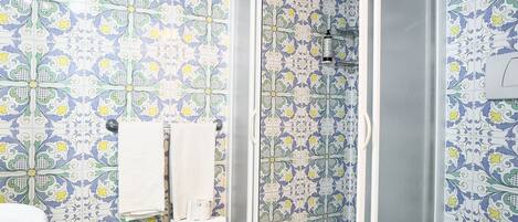 A bathroom with a shower, toilet, and sink.