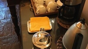 Ein reichhaltiges Buffet mit verschiedenen Speisen, einer Kaffeemaschine und Teeauswahl.