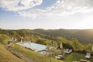 Een buitenzwembad en ligstoelen